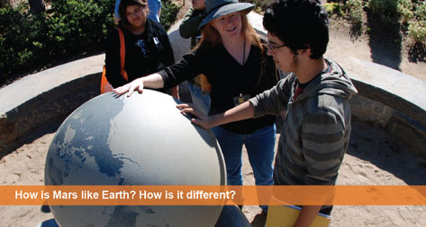 How is Mars like Earth? How is it different? Several students around a globe of the Earth.