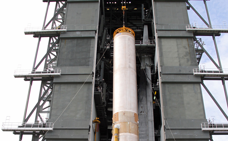 A crane lifts the 106.5-foot-long first stage of the Atlas V rocket for NASA's Mars Science Laboratory (MSL) mission through the open door of the Vertical Integration Facility at Space Launch Complex 41 on Cape Canaveral Air Force Station.