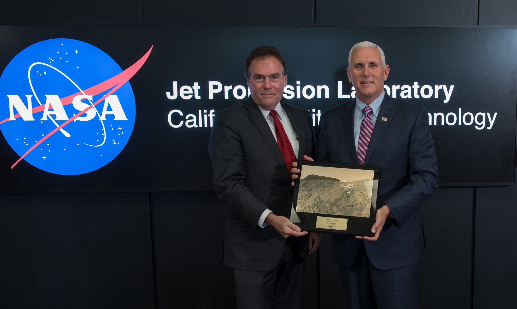 U.S. Vice President Mike Pence, right, is presented a plaque by JPL Director Michael Watkins during a tour of NASA's Jet Propulsion Laboratory, Saturday, April 28, 2018 in Pasadena, California. The plaque presents a view of the Mars Science Laboratory rover Curiosity on the surface of Mars. Photo Credit: (NASA/Bill Ingalls)