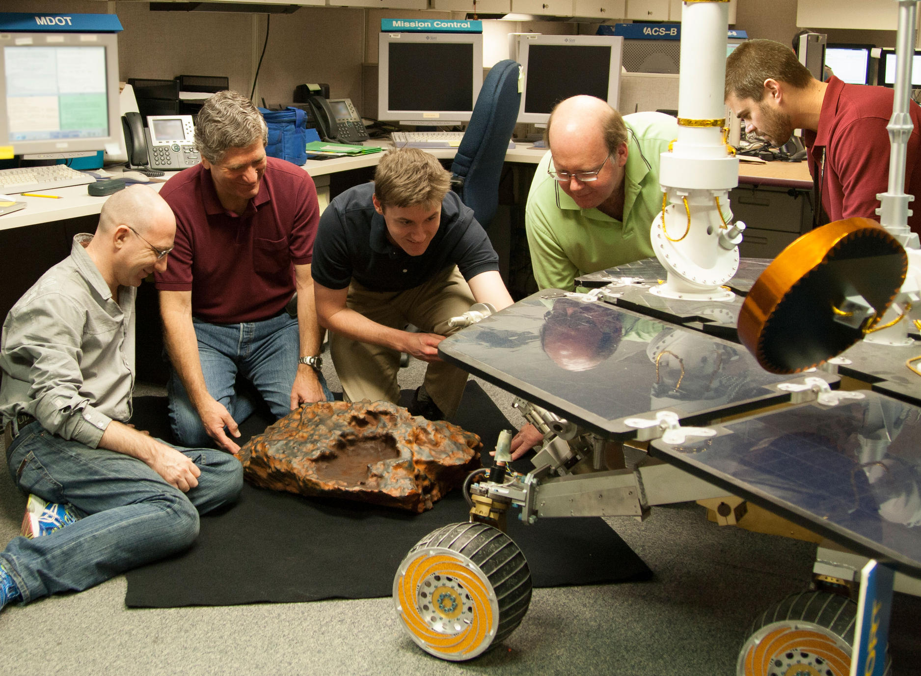Researchers with Meteorite and Rover Models